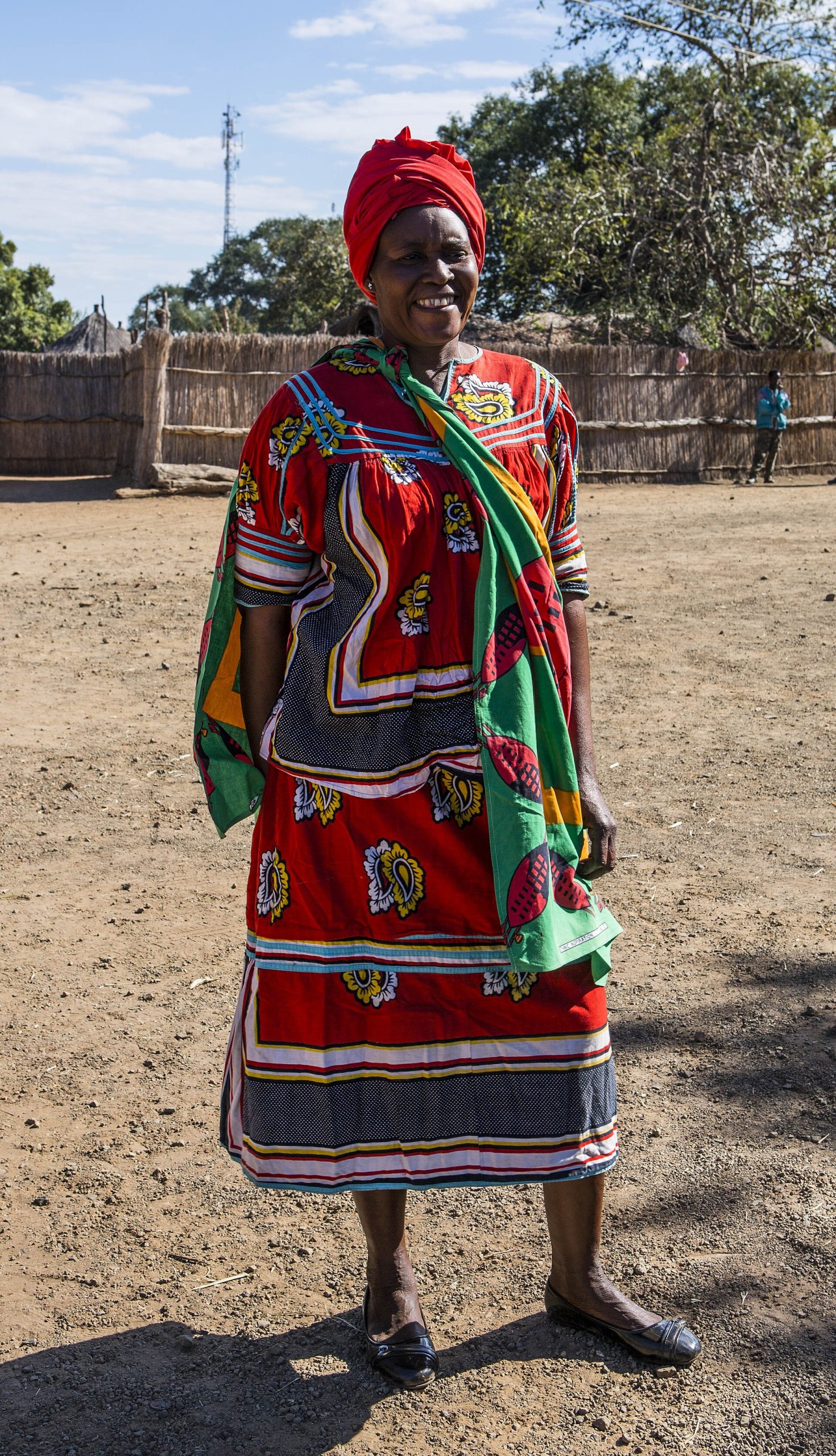 Woman in colourful chitenge dress, Mukuni village, Zambia