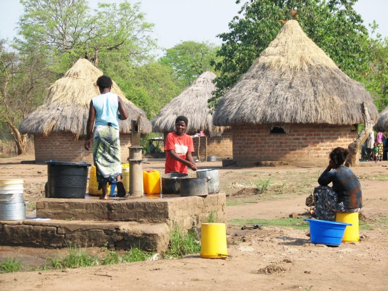 Women drawing water from the well in a Zambian village